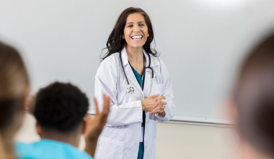 Female medical professor laughs at student's joke