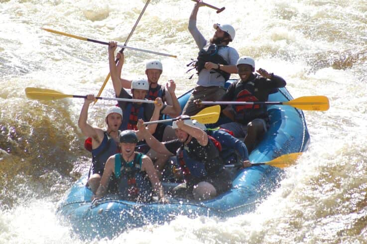 students crash down river rapids in a raft