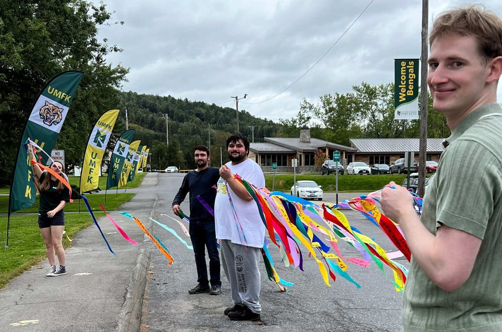 photo of UMFK Gratitude Project students hanging banners along University Drive