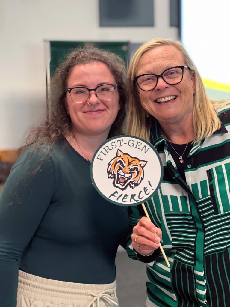 First-generation student Madi Martin poses with President Deb Hedeen. President Hedeen is holding a sign with a Bengal face on it with the words, "First-Gen Fierce!"