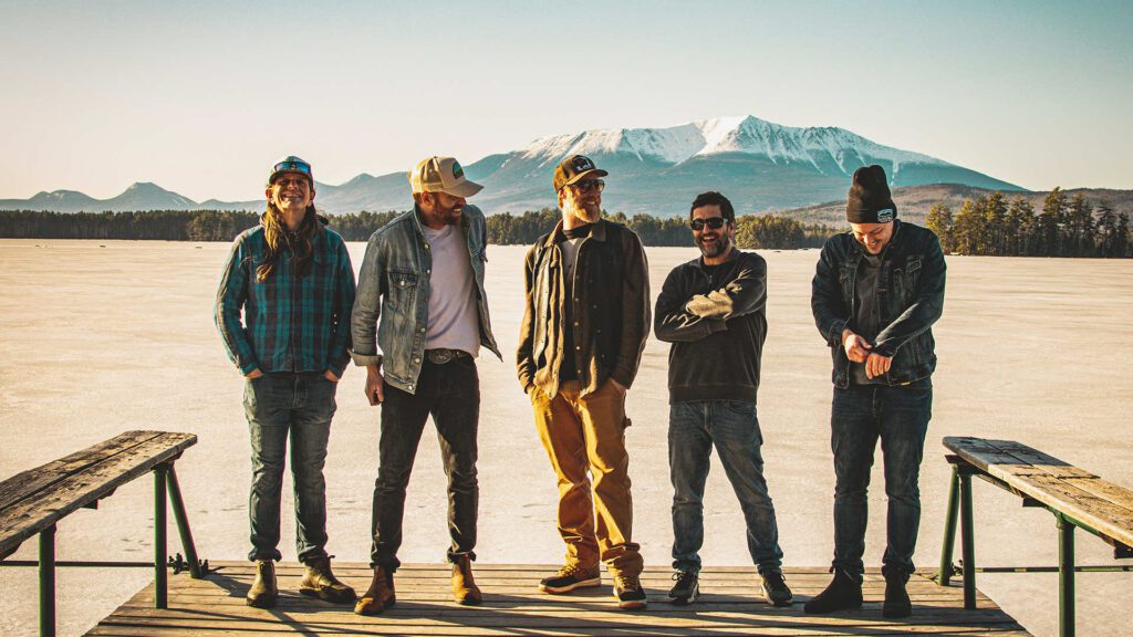 The Mallett Brothers Band members stand together with a mountain looming in the background