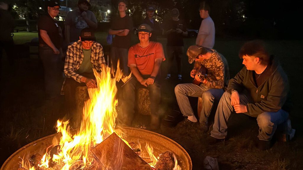 umfk students sit around a bonfire at Crocker Beach